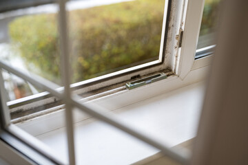 Dirty plastic window. Dust-covered plastic window frame and sill with dirt buildup and stains. Spring home cleaning concept