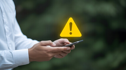 Mobile alert concept with smartphone and glowing yellow warning triangle symbolizing caution and digital risk