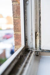 Dirty plastic window. Dust-covered plastic window frame and sill with dirt buildup and stains. Spring home cleaning concept