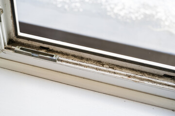 Dirty plastic window. Dust-covered plastic window frame and sill with dirt buildup and stains. Spring home cleaning concept