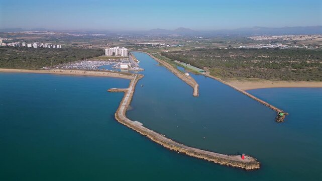 Aerial view of Guardamar del Segura, a town on the Costa Blanca in Spain. Segura River flowing to the Mediterranean Sea, marina with boats, sandy beaches and surrounding urban and natural landscapes.