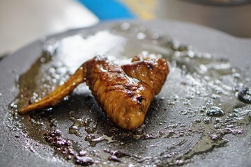 Close-up of grilled chicken wings with a golden brown surface, depicting a delicious and appetizing...