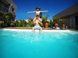 casal juntos se divertem em piscina no ver&atilde;o 