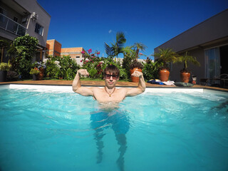 homem forte na piscina no ver&atilde;o 