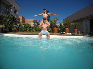 casal juntos se divertem em piscina no ver&atilde;o 