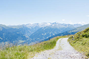 Obraz premium Winding mountain path leading to majestic peaks in the alps