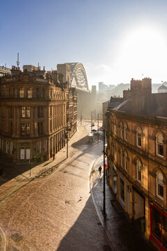 Newcastle Upon Tyne's Quayside, Tyne bridge and Grainger Town areas coloured golden at sunrise with a slight mist over the river