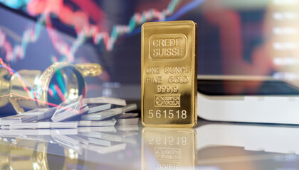 Gold bar and currency stacks with market chart