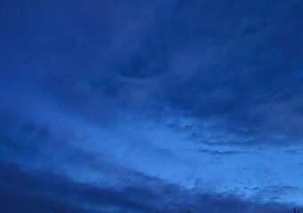 Fototapeta premium storm clouds timelapseDark blue afternoon sky with grey clouds.House silhoute with dark blue sky in evening after sundown