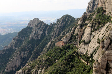Fototapeta premium Montserrat mountain with dramatic rocky formations and hilltop chapels and churches, creating a sacred spiritual landscape in Catalonia, Spain, taken in July 2024.