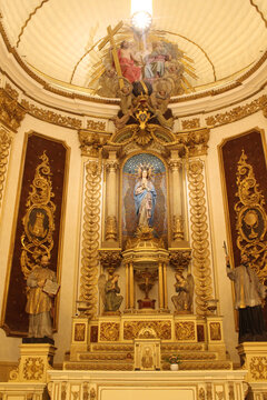 Interior of the Sanctuary Church of Saint Ignatius in Manresa featuring the altar, cross, virgin mary, mosaics, and statues of saints, taken in July 2024.