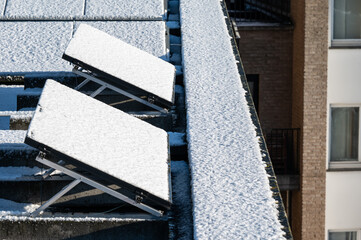 Snow-covered solar panels on flat roofs