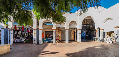 Open Air Market With Arched White Buildings, Clothing Stalls, And Shaded Courtyard, Agadir, Morocco