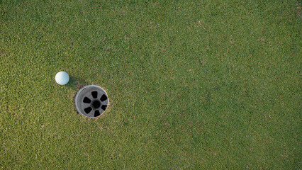 Obraz premium Golf ball is on a green lawn in a beautiful golf course with morning sunshine.