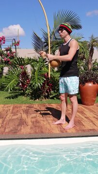 homem tocando instrumento birimbau capoeira cultura do brasil 