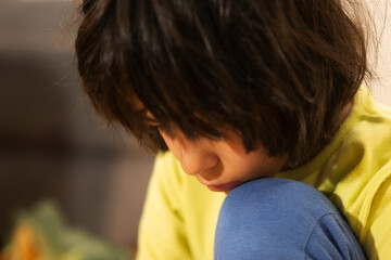 Obraz premium Young child contemplating and looking down with pensive expression