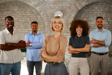 Confident diverse business team with folded arms smiling in office