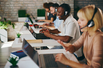 Diverse customer support team working in a modern call center office