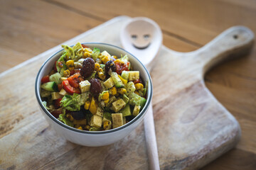 Healthy mixed farmer's salad with pieces of Gouda cheese and pumpkin seed oil