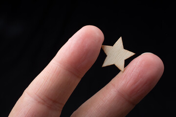 Hand hold wooden star sign. Product service evaluation concept