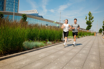 Couples running together on a city pathway