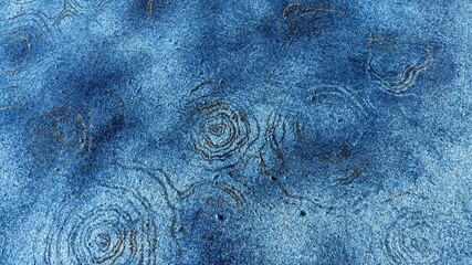 A close-up texture of a blue carpet featuring abstract swirl patterns and rough fabric details, creating a unique and artistic background for interior design or creative projects.
