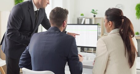 Team colleagues in office meeting analyze data. A manager points at a computer as the business group reviews analysis and aligns strategy for upcoming goals. Clear teamwork and leadership. - Powered by Adobe