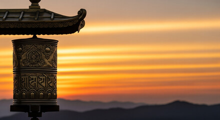 Golden prayer wheel with sacred script against a beautiful sunset sky, symbolizing spiritual devotion and peace for religious tradition.