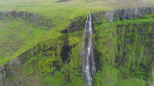 Waterfall falling from the high cliff in Iceland from drone