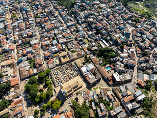 Imagem aérea de São Tomé das Letras em Minas Gerais. Casas, chão de pedra, turistas e comércio.