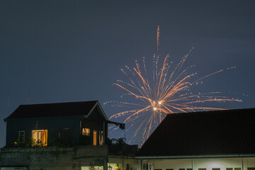 Nighttime fireworks over the city rooftops