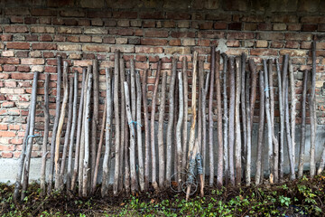 Obraz premium Stacked Branches Against Brick Wall