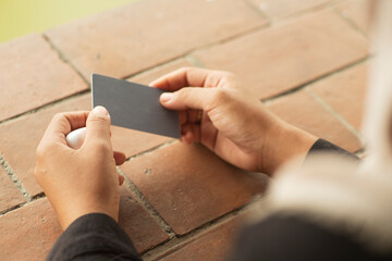 Closeup Hands Holding Blank Card mockup on tile surface