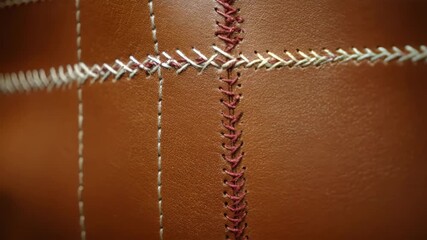 Medium shot showing detailed stitching repair on a leather bag highlighting the restoration process