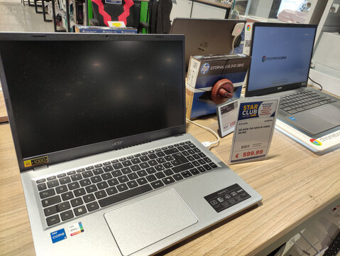 Rome, Italy - January 02, 2026: Acer laptop displayed on wooden table in electronics store with price tag and nearby HP laptop, showcasing modern technology and retail environment