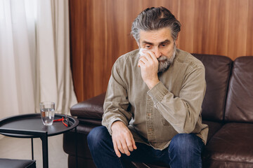 Crying older man wiping tears during therapy session