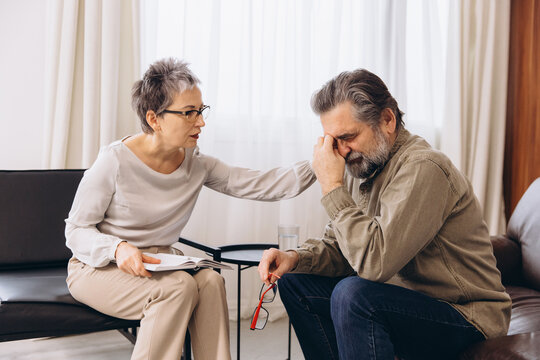Psychologist comforting senior man during therapy session - Powered by Adobe