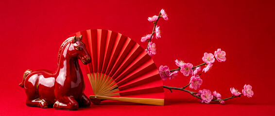 porcelain figurine of a red horse on a bright red background and plum blossom branches, a poster for Chinese New Year greetings