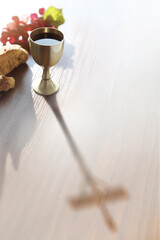 The bread and wine of the Eucharist and the inverted shadow of the cross symbolizing the suffering of Jesus Christ
