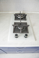 Modern gas cooktop on white kitchen countertop.
