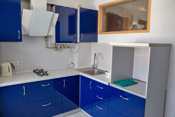 Modern blue kitchen interior with white countertop.