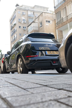 Rear view from a low angle of a black ORA 03 electric hatchback parked on a city street near residential buildings, Ramat Gan, Israel, 23 December, 2025