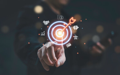 Business goal and target illustration with hand touching digital bullseye and arrow surrounded by...