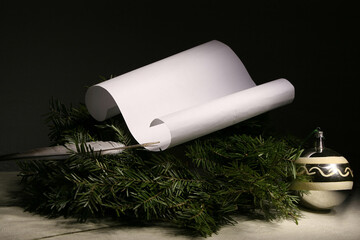 A sheet of paper for a greeting lies on fragrant fir branches.