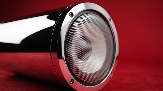 Metallic speaker on red background close up studio shot