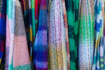 colorful woven textiles with rich patterns and soft fabric textures hanging side by side