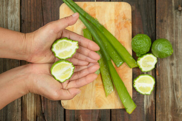 Authentic women are preparing kaffir lime and aloe vera, pure natural ingredients, for use in skin and hair care products.