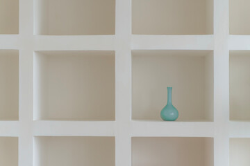Wooden shelf with empty vase on an open window frame against a blank wall in a minimalist room interior decoration