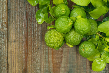 top view angle of kaffir lime in its natural habitat, placed on a wooden cutting board, ready to be used in cooking or for hair care.