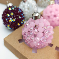 Collection of elegant handmade Christmas balls made of crystal  beads of different colors. Festive holiday decorations displayed in gift boxes . Luxury winter decor concept